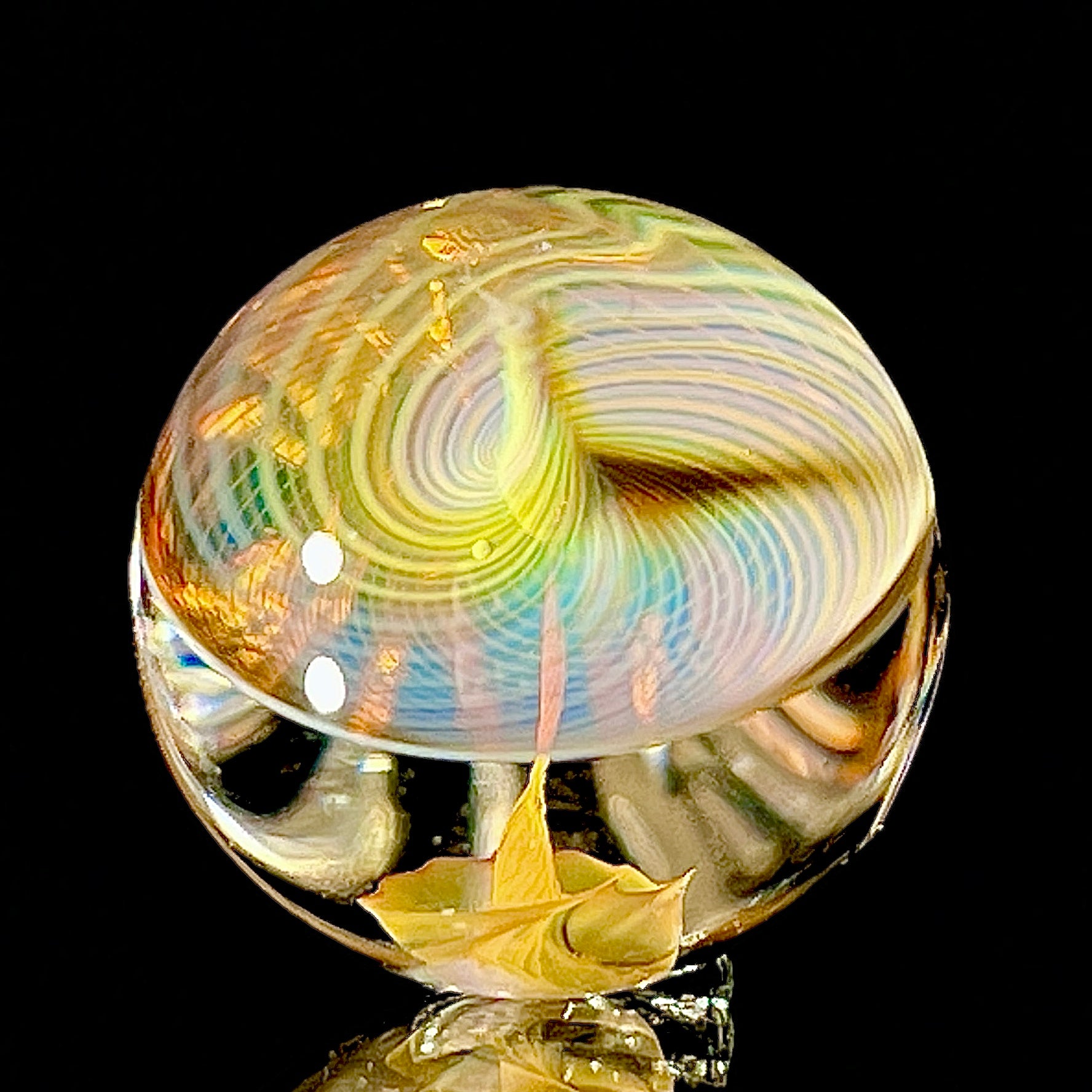 Colorful glass orb with swirling patterns on a black background