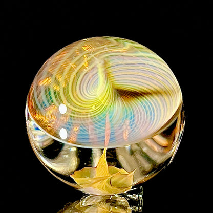Colorful glass orb with swirling patterns on a black background