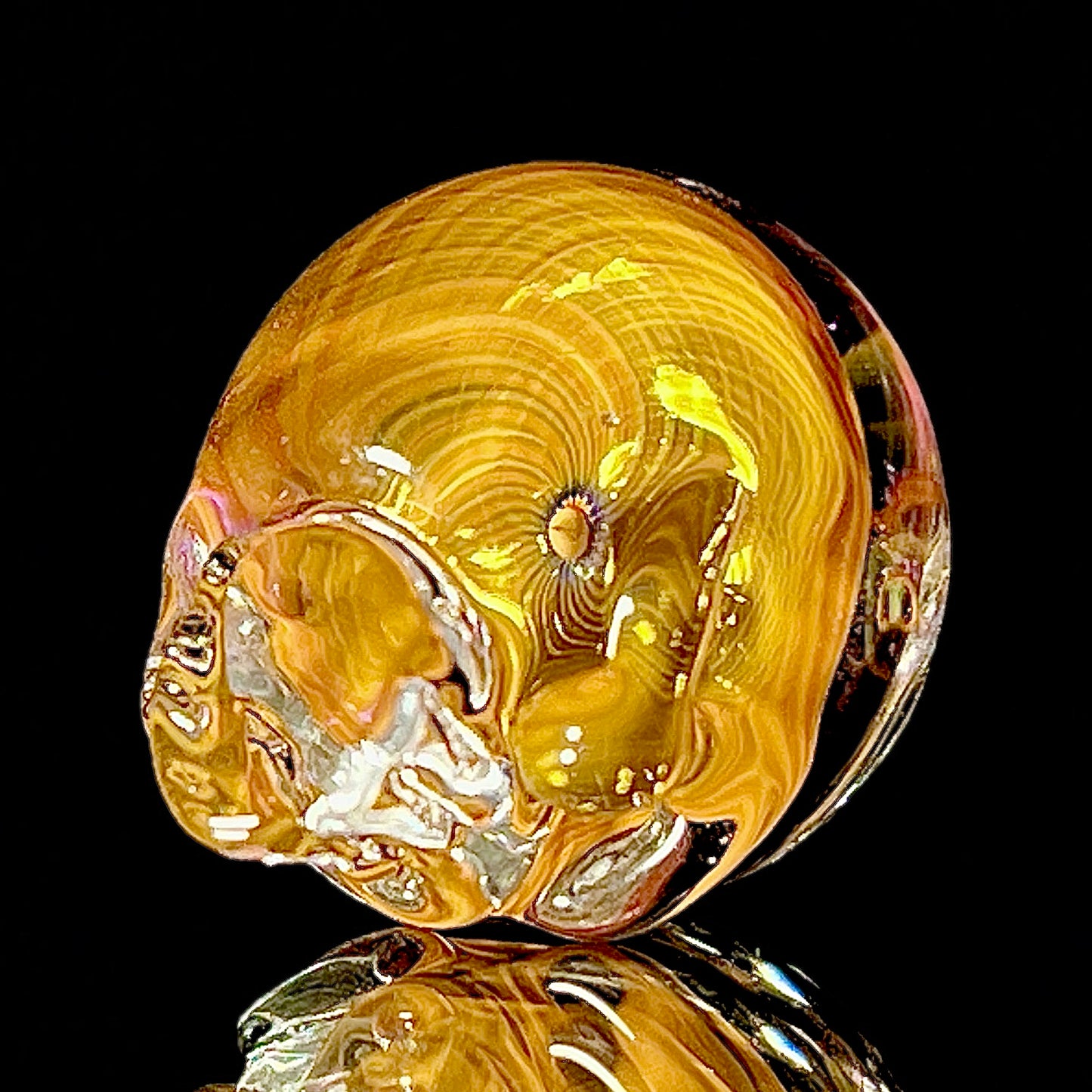 Glass sculpture with gold and silver colors on a black background