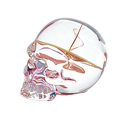 Glass skull with gold accents on a white background.