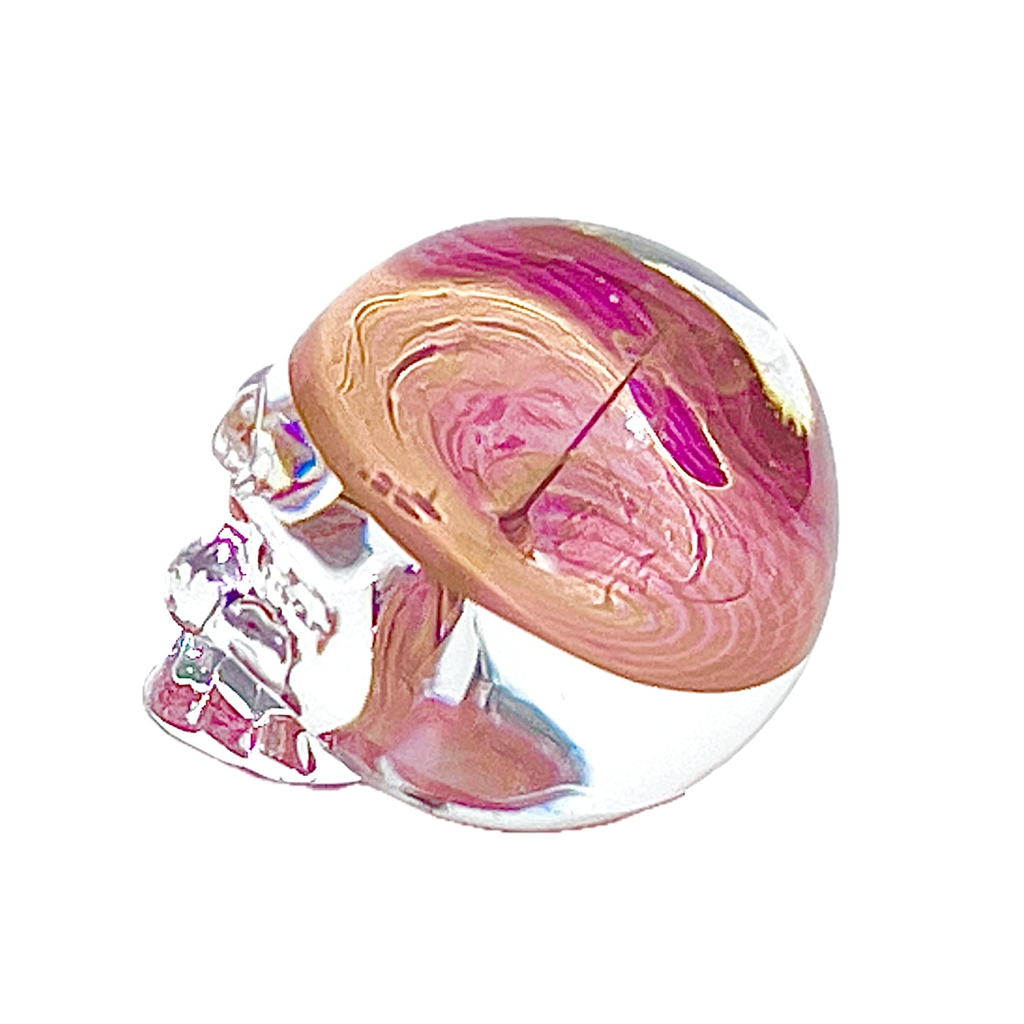 Glass skull with pink and gold interior on a white background.