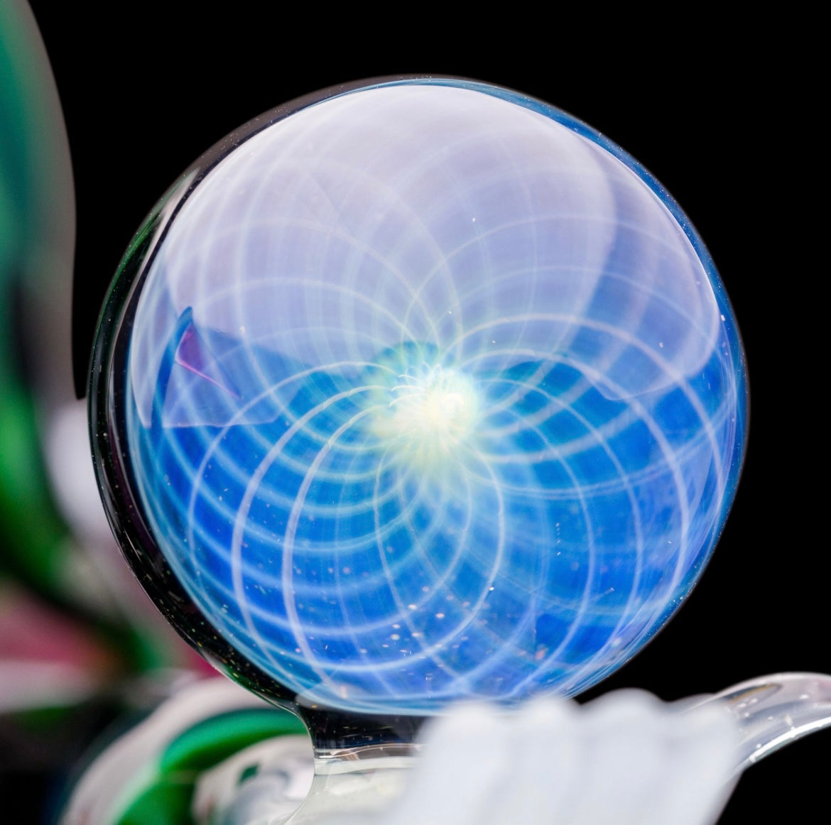 A custom glass piece by Joachim Dallant featuring a winged reaper figure with a colorful backdrop, incorporating a Fumicello orb and a removable scythe dabber.