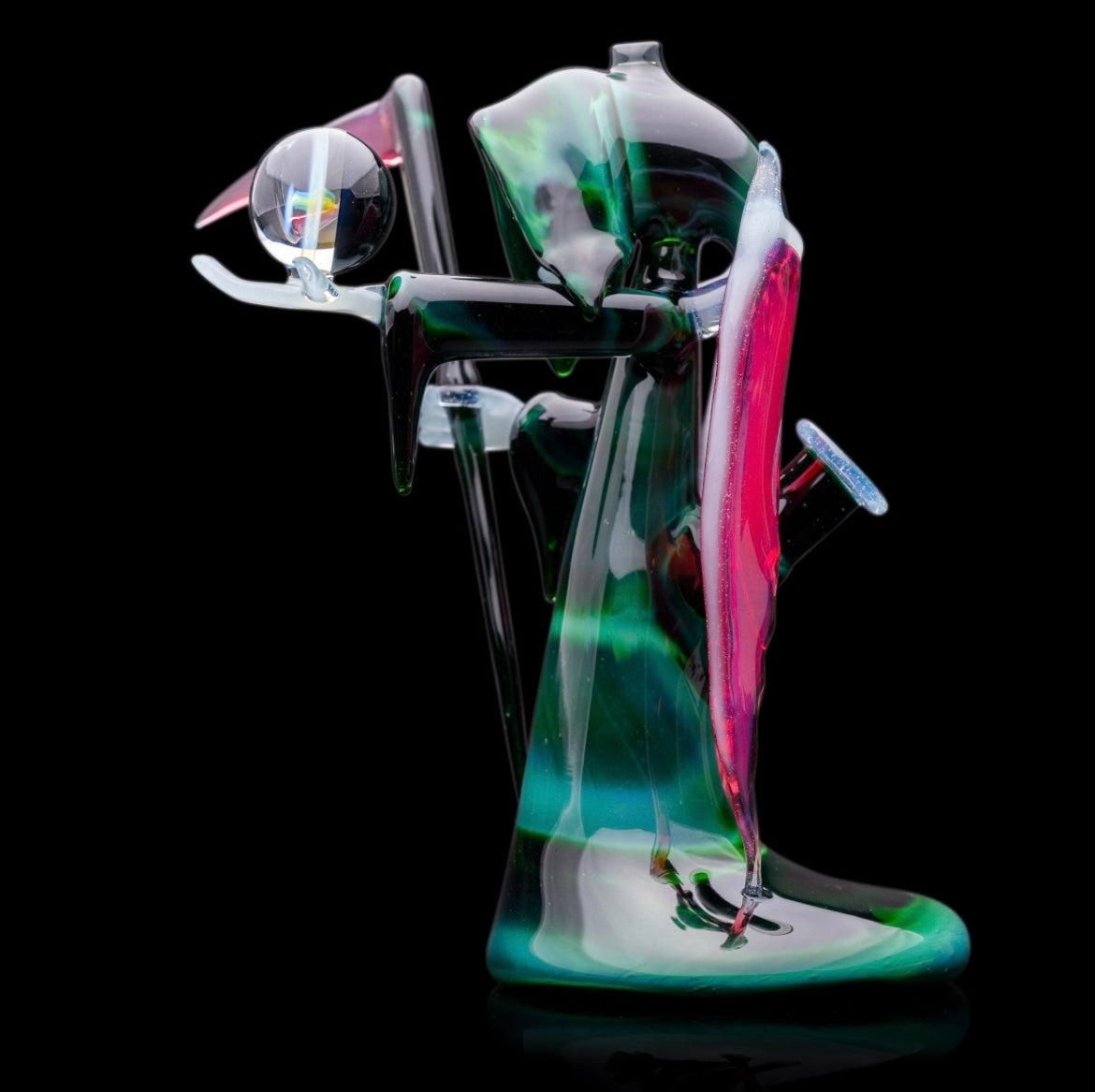 A custom glass piece by Joachim Dallant featuring a winged reaper figure with a colorful backdrop, incorporating a Fumicello orb and a removable scythe dabber.