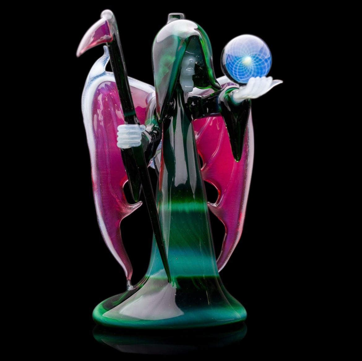 A custom glass piece by Joachim Dallant featuring a winged reaper figure with a colorful backdrop, incorporating a Fumicello orb and a removable scythe dabber.