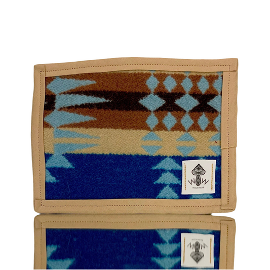 A rectangular Pendleton mat featuring geometric patterns with upcycled fabric, displaying a blend of earthy tones and blue.
