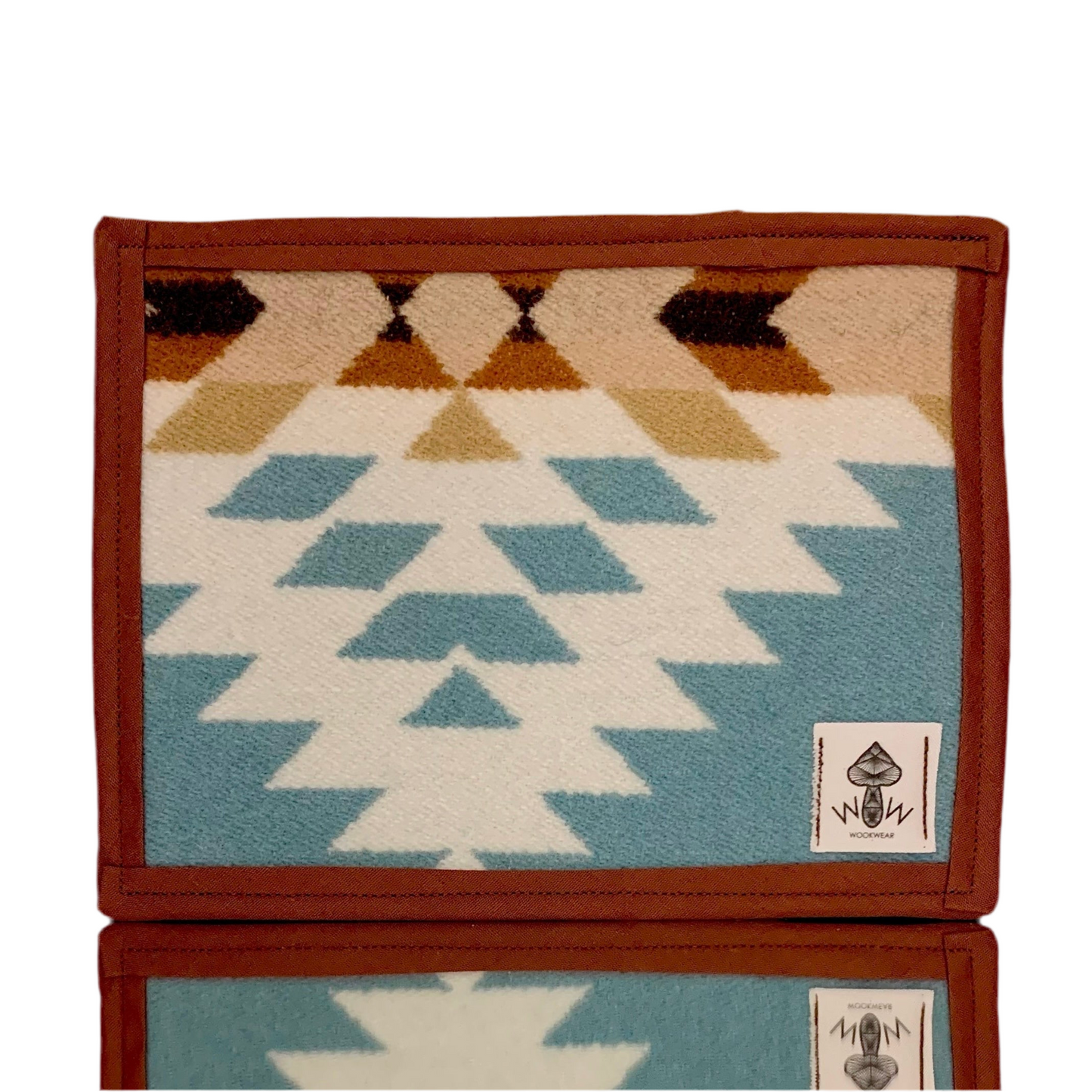 A rectangular Pendleton mat featuring an upcycled fabric design with geometric patterns in beige, blue, and brown colors.