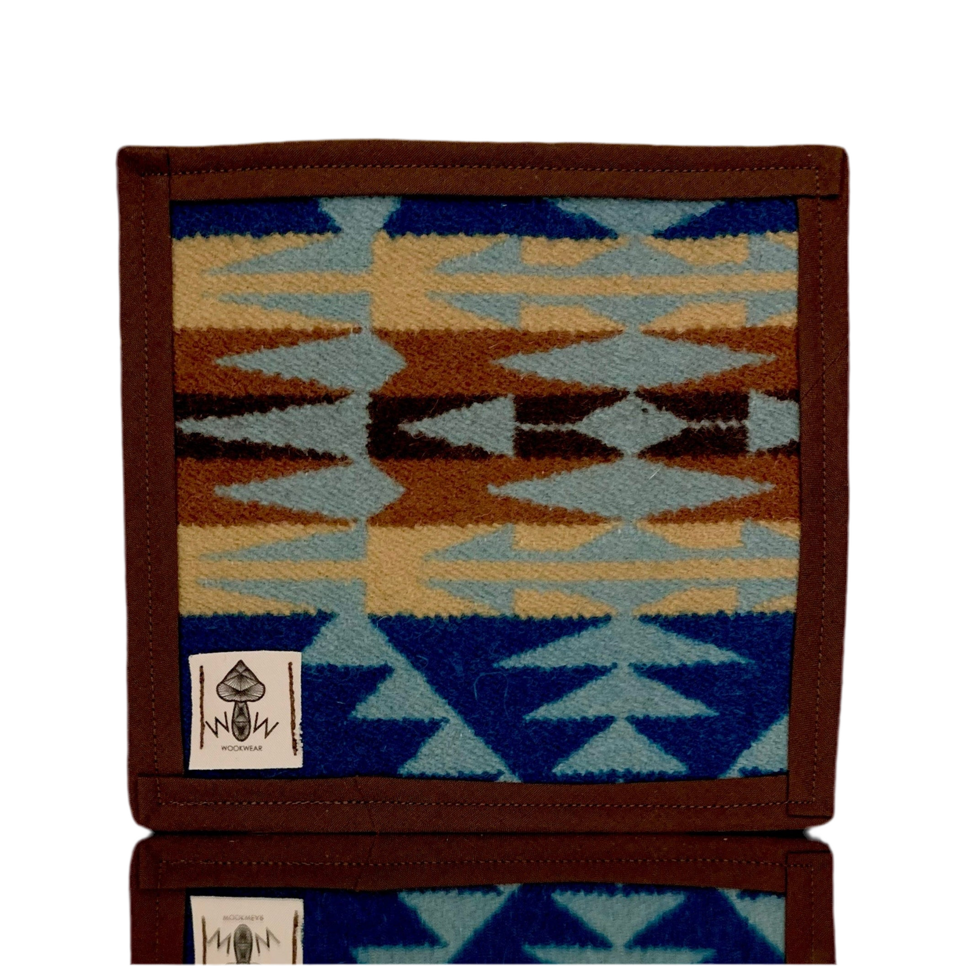 A upcycled fabric pen holder with a geometric pattern in blue, brown, and beige colors, featuring the Wook Wear brand label.