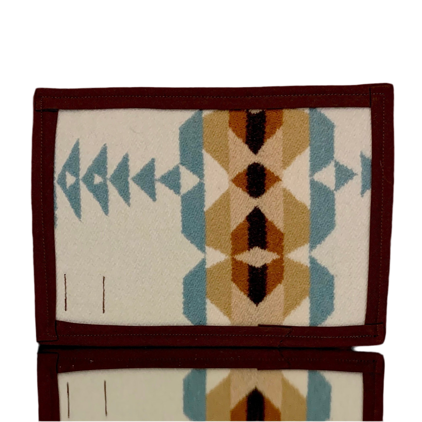 A rectangular Pendleton mat featuring a geometric pattern with red, blue, and beige colors on a white background, with a dark border.
