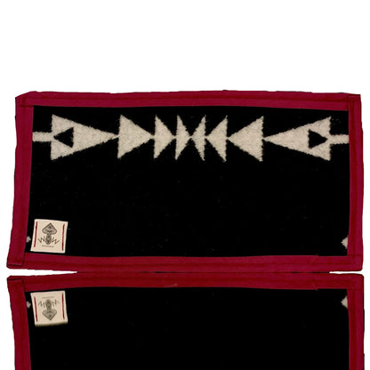 A rectangular Pendleton mat featuring a black and white geometric pattern with a red border.