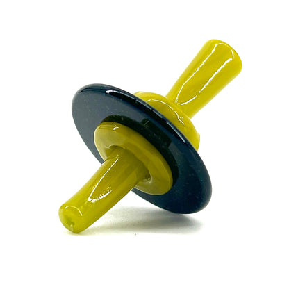 Yellow and black glass stopper on a white background.