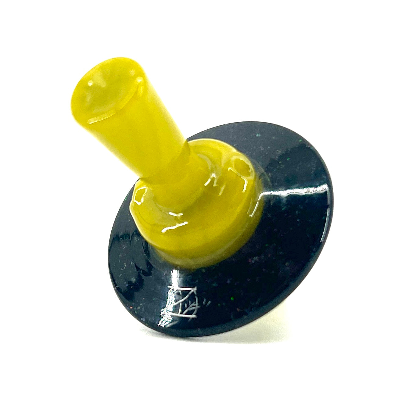 Yellow cap with a dark circular base with white speckles against a white background.